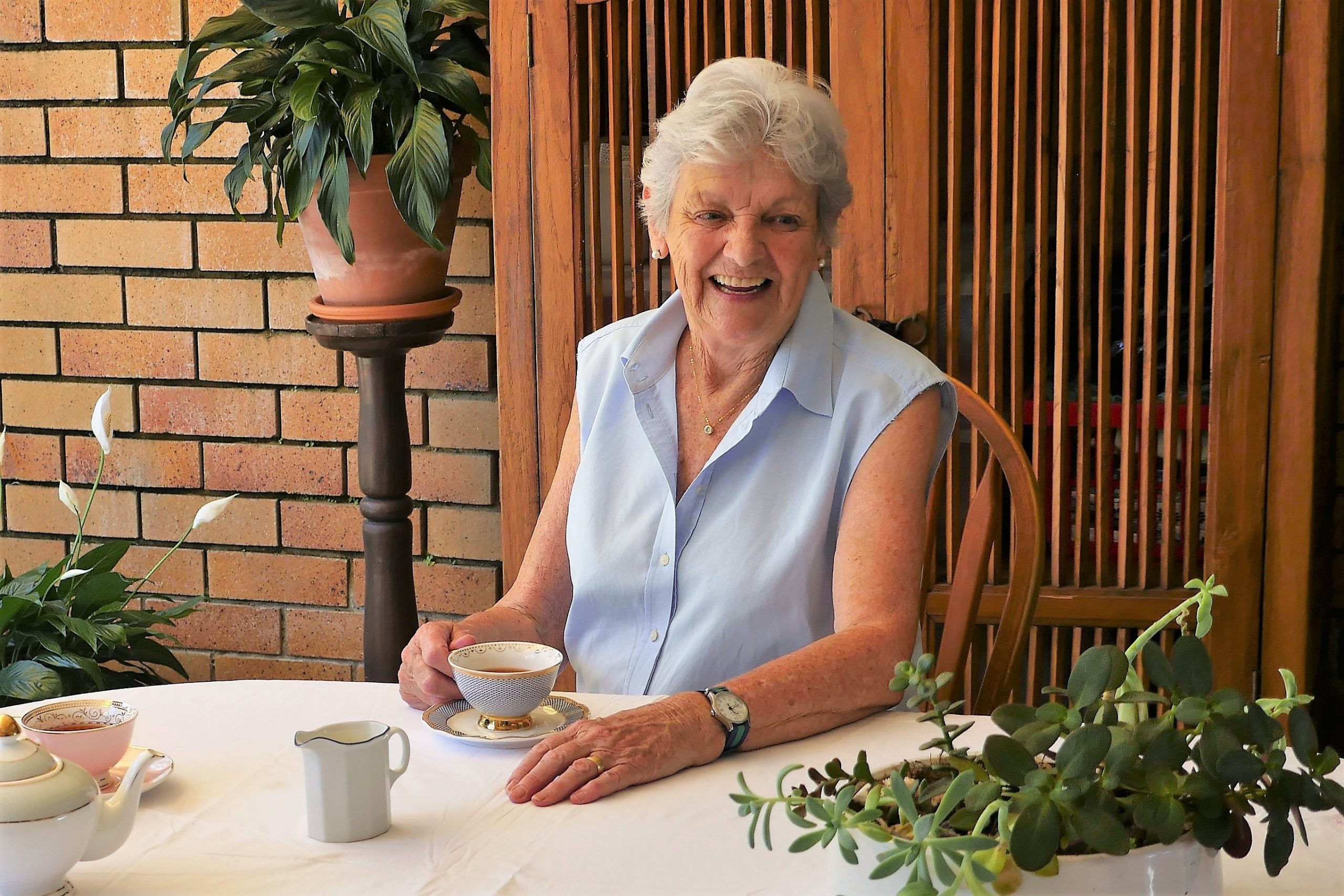 older woman sitting at table having tea